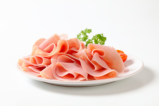 Thinly sliced ham on plate