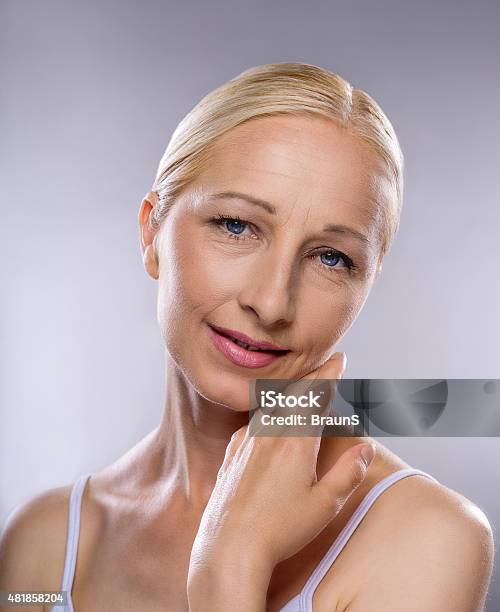 Smiling Mature Woman Touching Her Soft Skin Stock Photo - Download Image Now - 2015, 40-44 Years, Adult