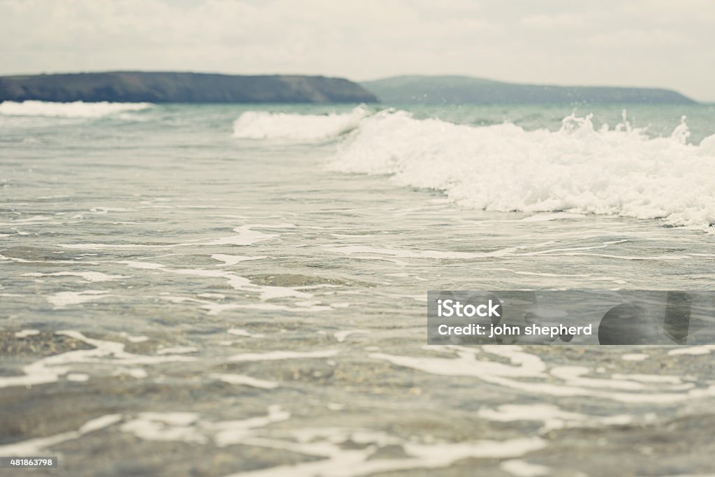 waves rolling in at Perranporth Beach gentle wave rolling into the beach at Perranporth, North Cornwall on a bright June day. 2015 Stock Photo