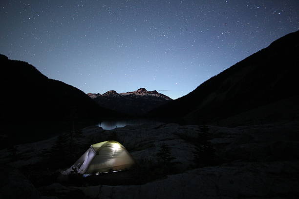 istock Illuminated tent at a lake under starry night 481864670