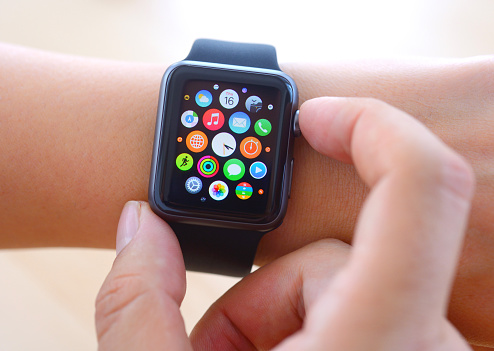 İstanbul, Turkey - July 16 2015: Hand touching an Apple Watch displaying home screen. Apple Watch is a smart watch, devices developed by Apple Inc.