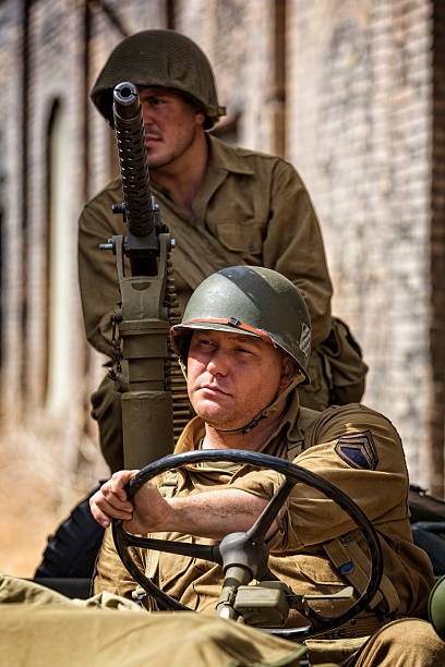 Army Sargeant Waits at the Wheel While on Patrol A army sargeant waits for orders while at the wheel of his Jeep as well as the machine gunner on patrol. jeep 4x4 off road vehicle world war ii stock pictures, royalty-free photos & images