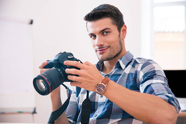 istock Happy man sitting at the table with photo camera 481869184
