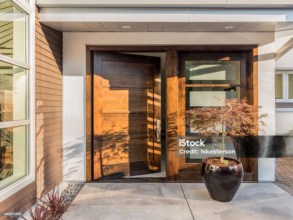 Beautiful Doorway To New Luxury Home Large and Wide Hardwood Door Slightly Ajar at Entrance to House Door Stock Photo