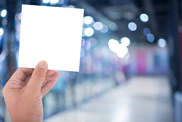 istock hand hold blank square paper over blur background 481874192