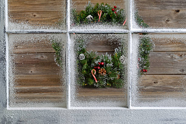 istock Snow covered window with decorative Christmas wreath on rustic w 481874558