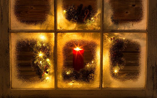 istock Snow covered window with glowing candle and decorative Christmas 481878996