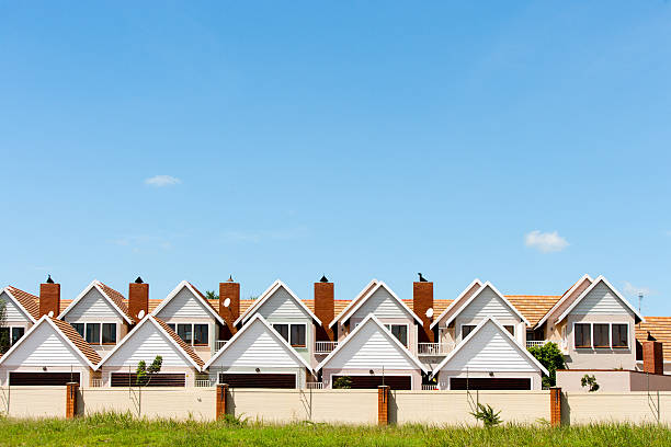 Townhouses. Residential fenced house complex against blue sky. row-house stock pictures, royalty-free photos & images