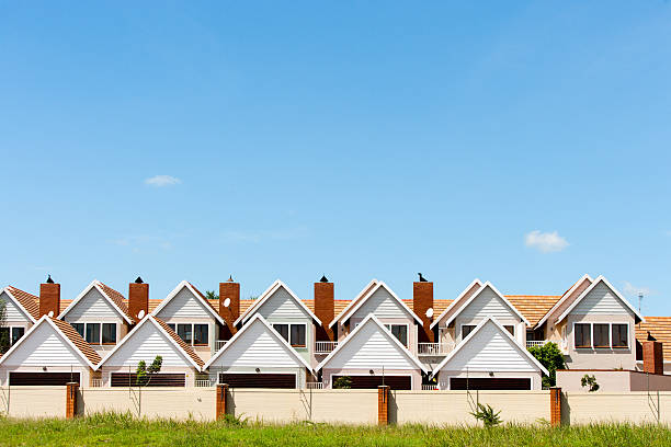 Townhouses. Residential fenced house complex against blue sky. row house stock pictures, royalty-free photos & images