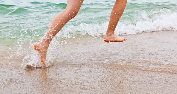 istock feet of boy running along the beach 481881247