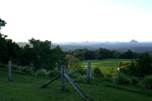 Glass House Mountains with Mist and Foreground Farm at Daybreak stock photo