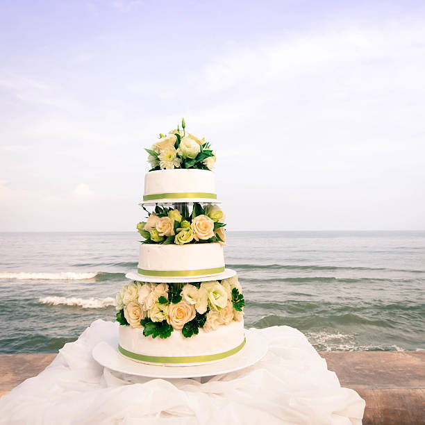 istock White and roses wedding cake by the beach 481885177