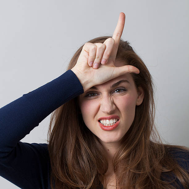 istock mean 20's woman accusing herself or someone with L sign 481886164
