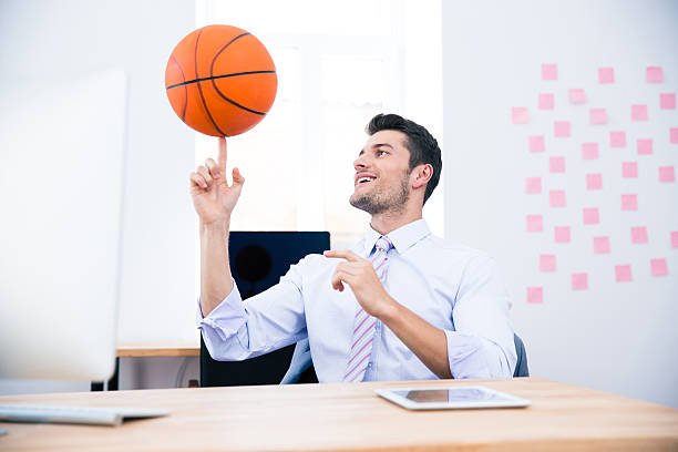 istock Smiling businessman spining ball in office 481887294