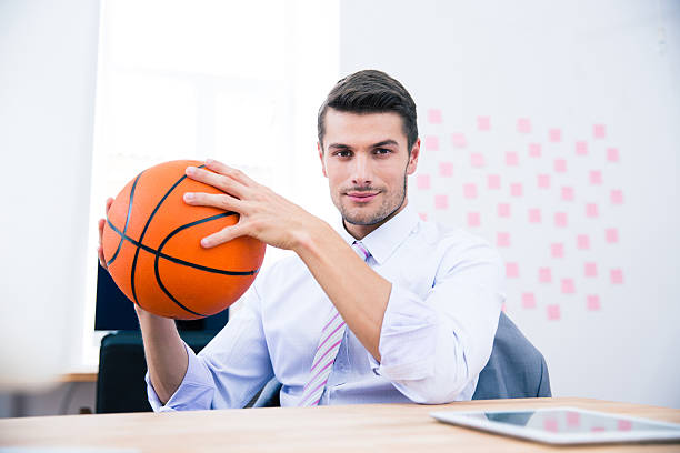 istock Businessman sitting at the table and holding ball 481887302