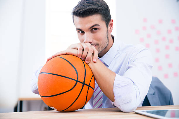 istock Handsome businessman sitting at the table with ball 481887308