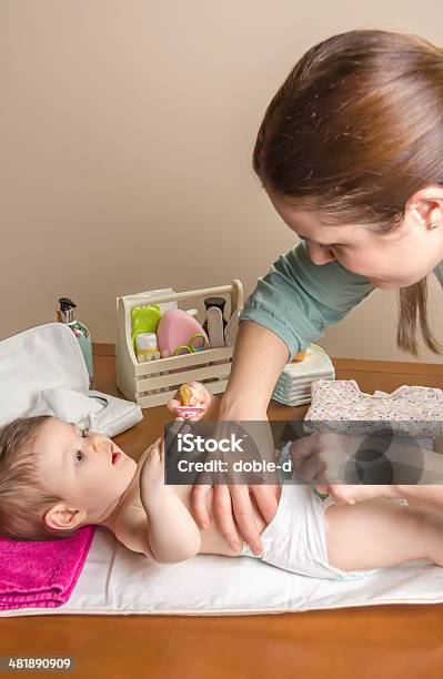 Mother Changing Diaper Of Adorable Baby Stock Photo - Download Image Now - Adult, Baby - Human Age, Care