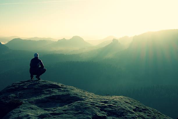 istock Hiker sits on a rocky peak and enjoy mountains scenery 481891642