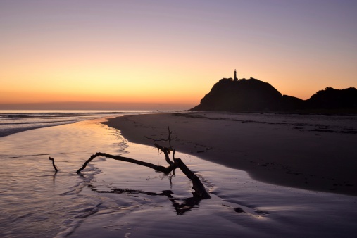 Dawn at the fort beach in Ilha do Mel, Paraná, Brazil with lighthouse at the top of the hill.