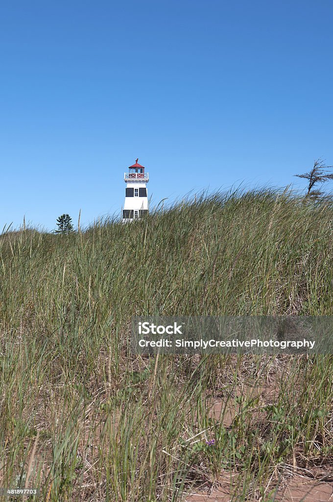 West Point Lighthouse by Grass Dunes, PEI Lighthouse on the sand dunes at West Point, Prince Edward Island, Canada. Architecture Stock Photo