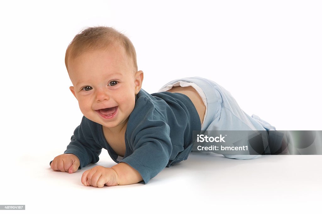 Happy Baby in Blue Adorable baby girl crawling and smiling. Beautiful smile shows the beginning of two lower front teeth. Baby - Human Age Stock Photo