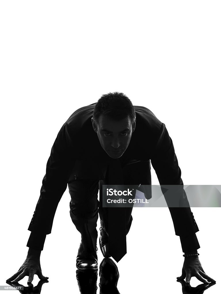 business man silhouette on starting block one caucasian business man on starting block in silhouette on white background Adult Stock Photo