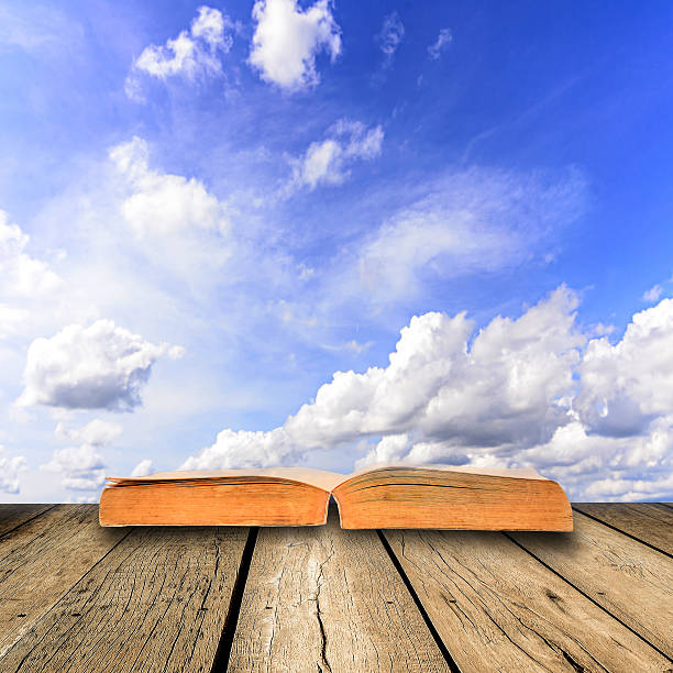 istock Open book on wooden floor with blue sky 481906945
