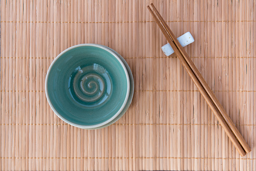 Empty Bowl With Chopsticks on Bamboo Mat