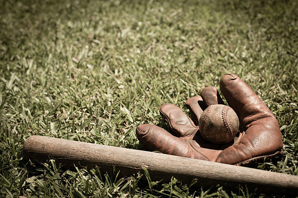 vieux baseball, gant & américain bat sur l'herbe à l'extérieur - baseball glove baseball baseballs old fashioned photos et images de collection