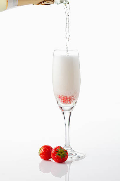 Flutes Filled with Champagne, Bunch of Dark Red Roses and Chocolate Cake on background