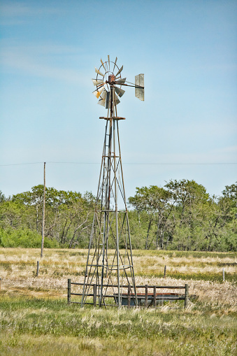 Vintage steel windmill used to pump water on pasture land.  These windmills were used on most farms to pump well water for people and animals and were occasionally used to generate electricity.