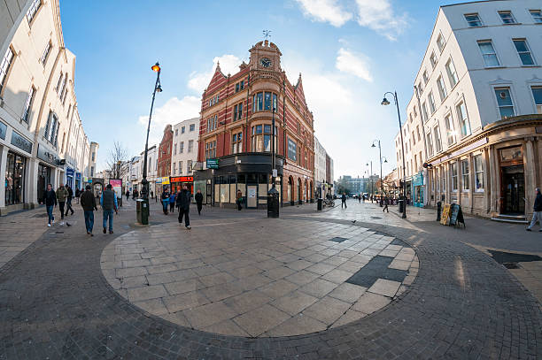 Cheltenham, United Kingdom - January 15, 2013: Pedestrians shopping on a busy city street in Cheltenham, England. Photograph shot with a fisheye lens.