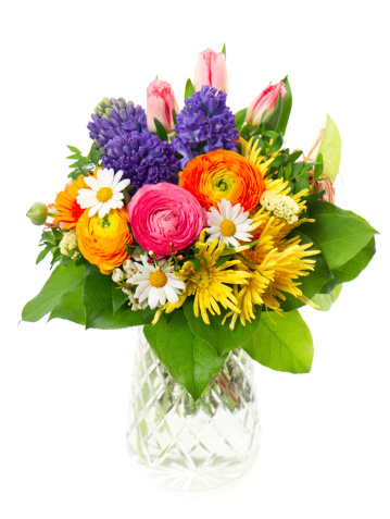 beautiful bouquet of colorful spring flowers in a glass vase. tulip, ranunculus, hyacinth, daisy, gerber