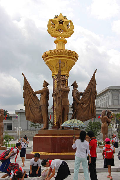 North Korea DPRK: Kumsusan Memorial Palace Of The Sun Pyongyang, North Korea - August 14, 2013: A group of school children on a field trip visit the Kumsusan Memorial Palace Of The Sun, and play by a statue of honour guards at the Kumsusan Memorial Palace Of The Sun (mausoleum of Kim Il Sung and Kim Jong Il). A palatial structure where the two leaders lay in state, and each has a museum dedicated to them. kim il sung mausoleum stock pictures, royalty-free photos & images