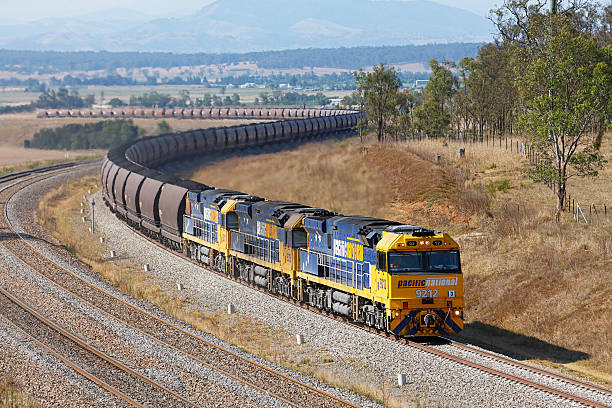 schwere pacific national coal zug schlängelt sich langsam geladen bergauf - land vehicle rail freight locomotive australia stock-fotos und bilder