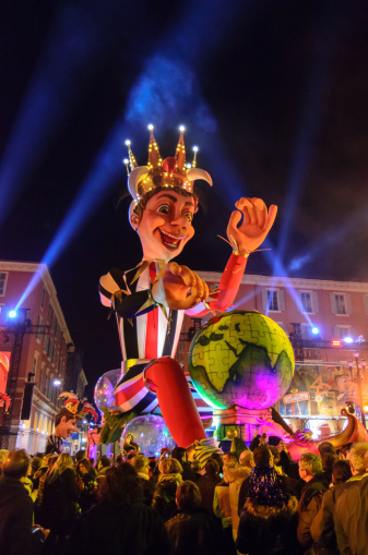Nice, France - 3rd March 2013: A giant floodlit papier mache float depicting a King leads the procession of floats into the Place Massena in Nice during the Night Carnival. The Nice Carnival is one of the oldest Carnivals in the world that takes place annually in February, with a parade of floats, entertainers, musicians and dancers