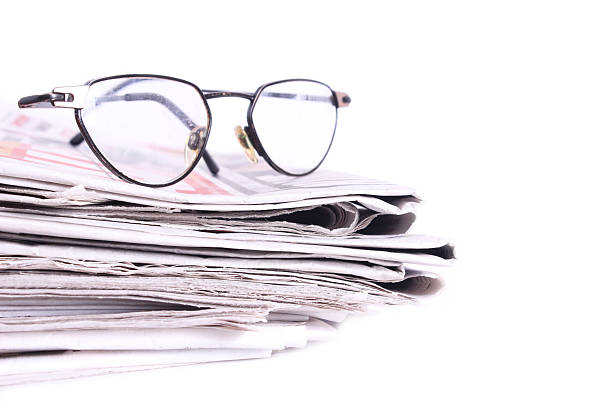 istock Newspaper pile and glasses 481921860