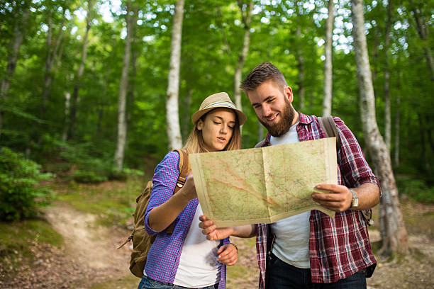 istock Couple of tourists using compass and map 481924778