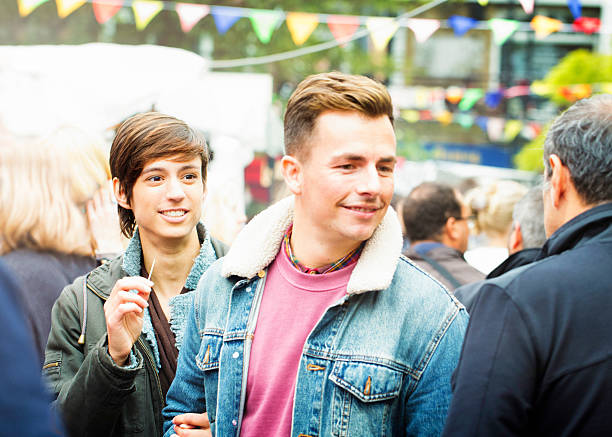 istock Young British couple making their way through crowd at  market 481934970