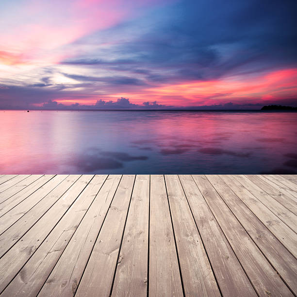 Wooden platform on beach with seascape and cloudy sky