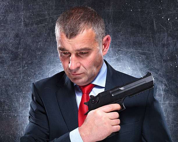istock pensive old assassin holding his gun 481944971