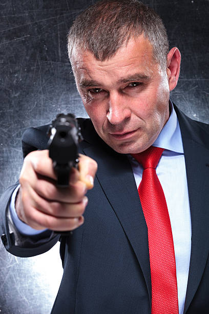 istock old killer in suit and tie pointing his gun 481946109