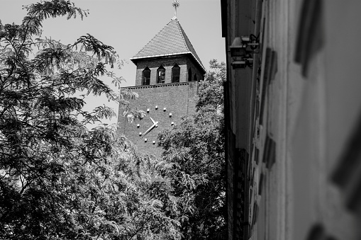 Clock on a building photographed in city center of Szeged, Hungary. Still working properly. Black and white photo.