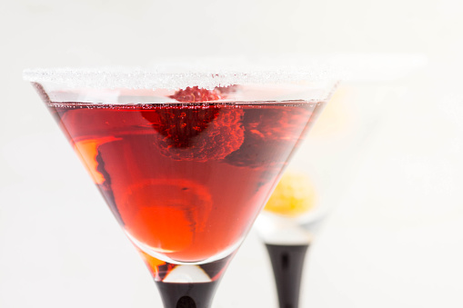 Red cocktail with raspberry on the white background