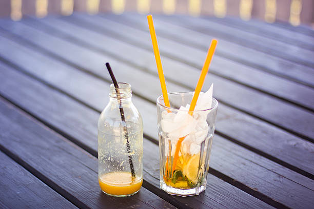 istock Empty bottle and glass with straws on a wodden table 481950366