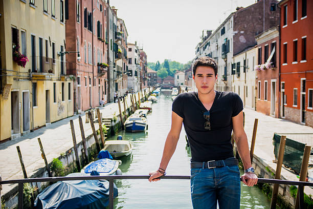 istock Young Man on Bridge Over Narrow Canal in Venice 481952552
