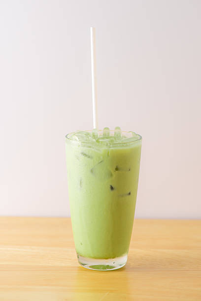 istock Ice Green tea with a straw on wood table 481958008
