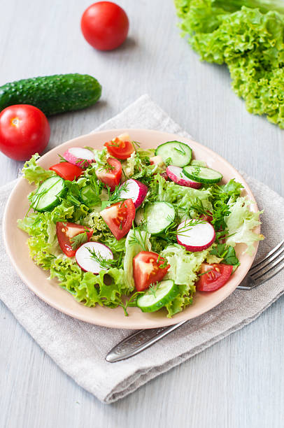 istock Tomato and cucumber salad with lettuce leafes 481958782