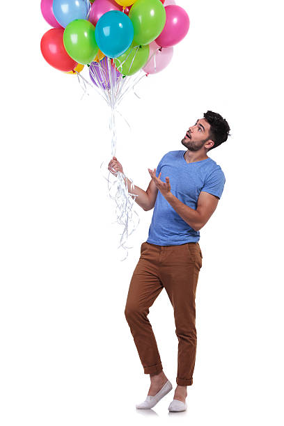 istock casual man presenting a bunch of balloons 481958949