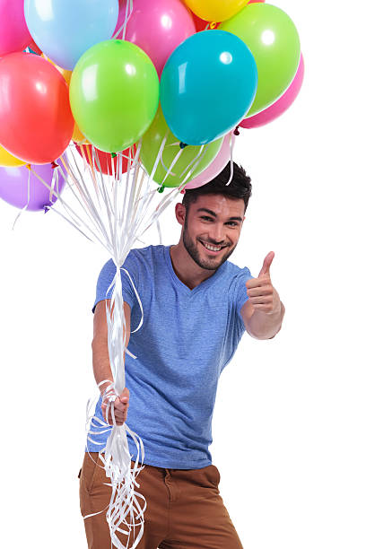 istock man holding a bunch of balloons and making ok 481958965